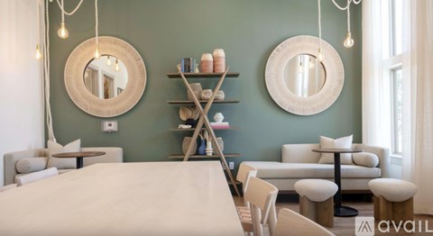A bedroom with a bed, a chair, a table, and a mirror on the wall.