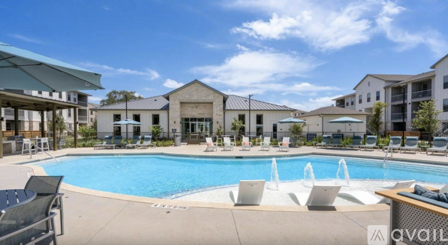 A pool with lounge chairs and a building in the background.