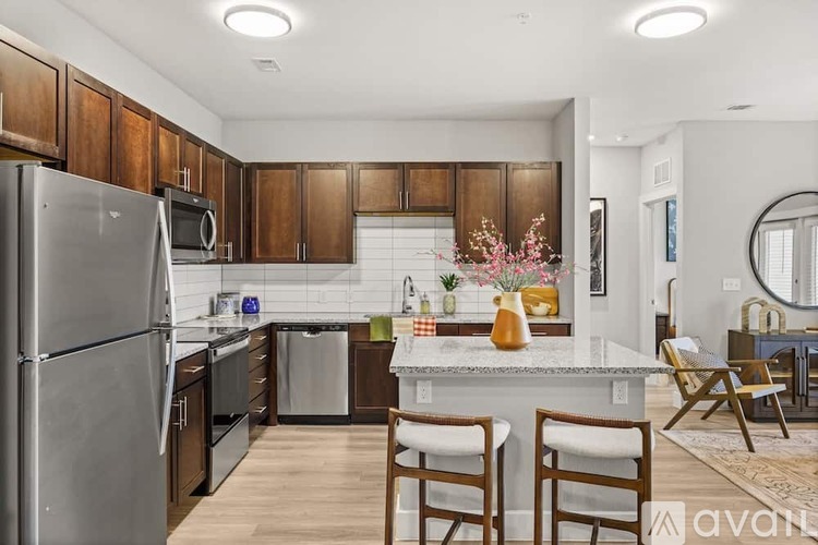 A kitchen with wooden cabinets and a stainless steel refrigerator.