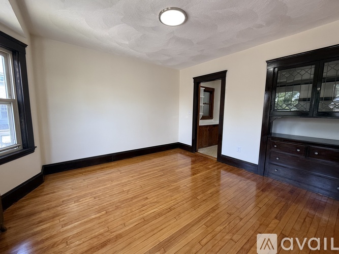 A room with a doorway leading to another room with a radiator.