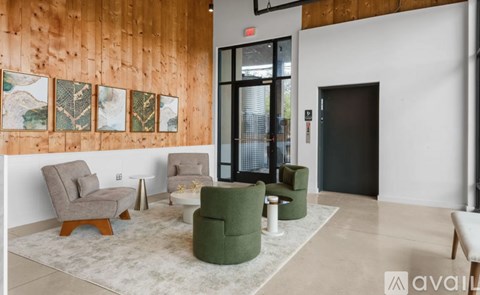 A living room with a white rug and a green chair.