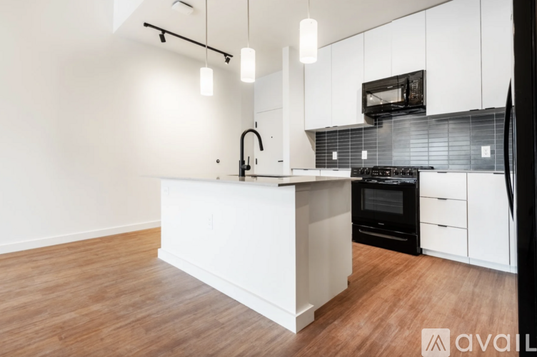 A modern kitchen with white cabinets and a wooden island.