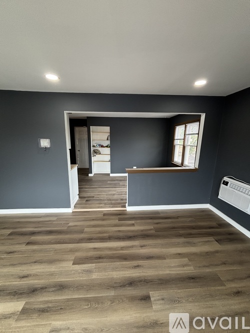A room with wooden flooring and a window.