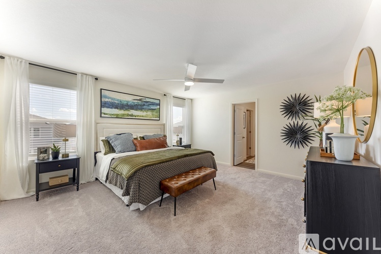 A bedroom with a large bed and a painting on the wall.