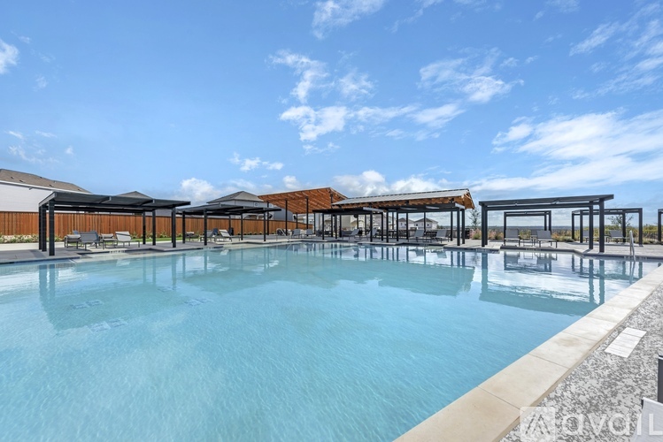A large outdoor swimming pool with a sun lounger area.