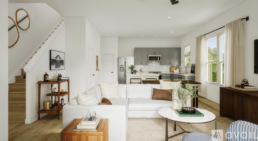 A modern living room with a staircase on the left side.