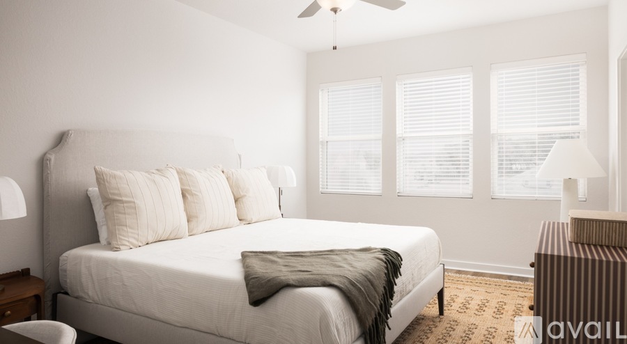 A bedroom with a large bed and a ceiling fan.