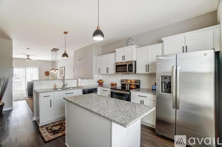 A kitchen with white cabinets and a granite countertop.