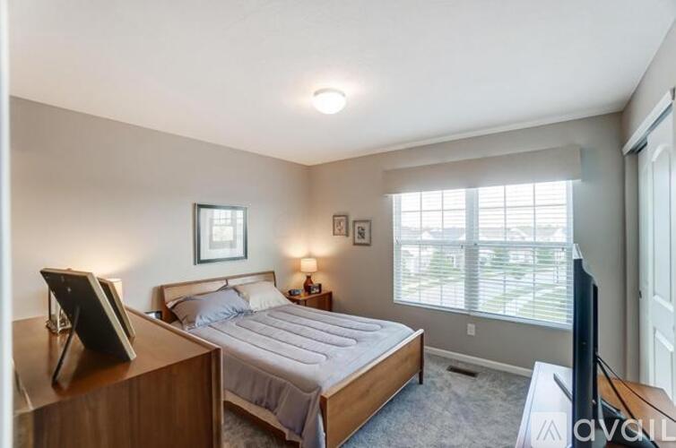 A bedroom with a bed, nightstand, and a television.