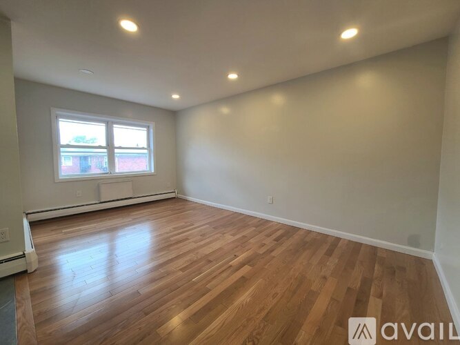 A room with wooden flooring and a window.