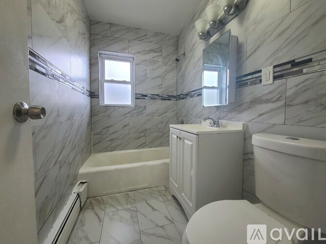 A bathroom with marble tiles and a white toilet.