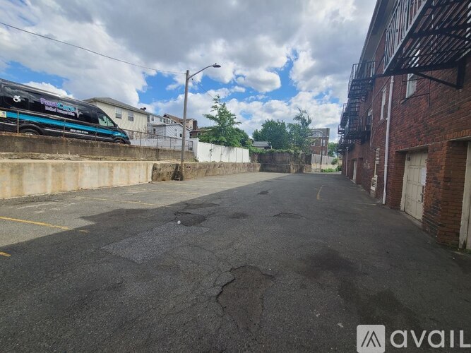 A parking lot with a blue van parked on the side.