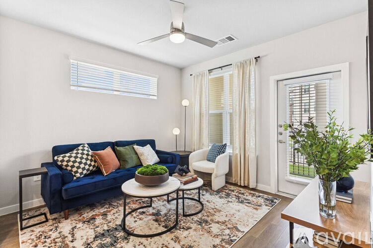 A living room with a blue couch and a rug.