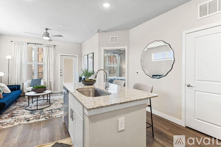 A kitchen with a counter and a round mirror on the wall.