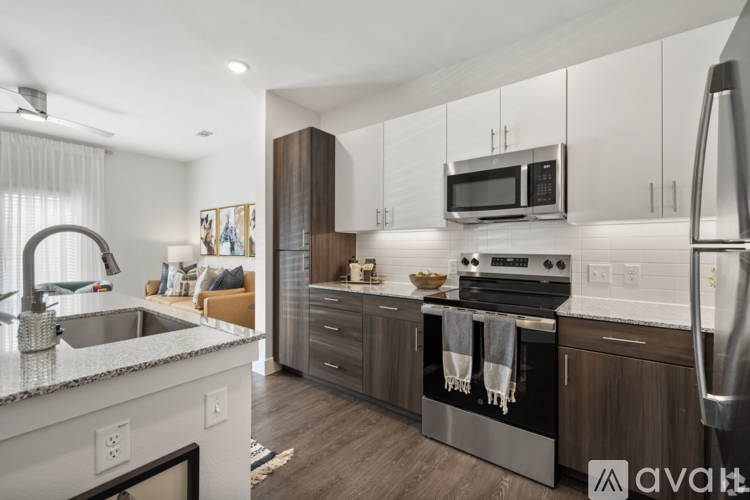 A modern kitchen with dark wood cabinets and stainless steel appliances.