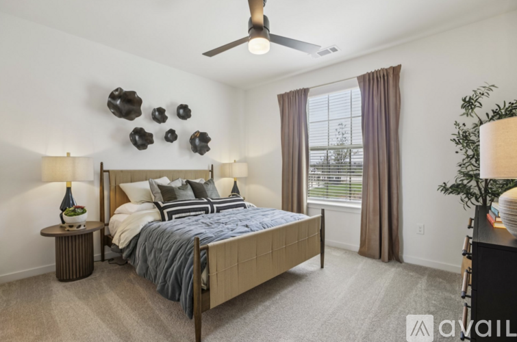 A bedroom with a bed, nightstands, and a ceiling fan.
