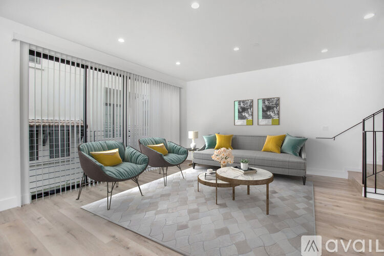 A living room with a grey sofa, two green armchairs and a coffee table.
