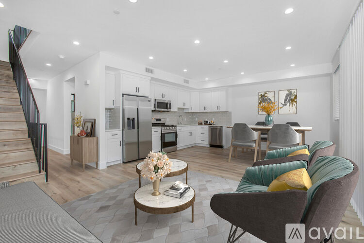 A modern kitchen with a dining area and a staircase.