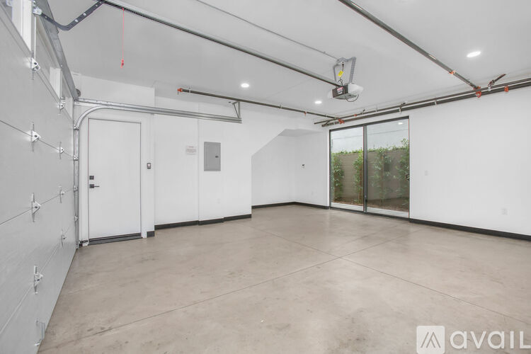 A spacious room with white walls and a concrete floor.