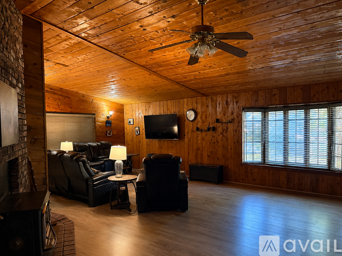 A living room with a wooden ceiling and a flat screen TV mounted on the wall.