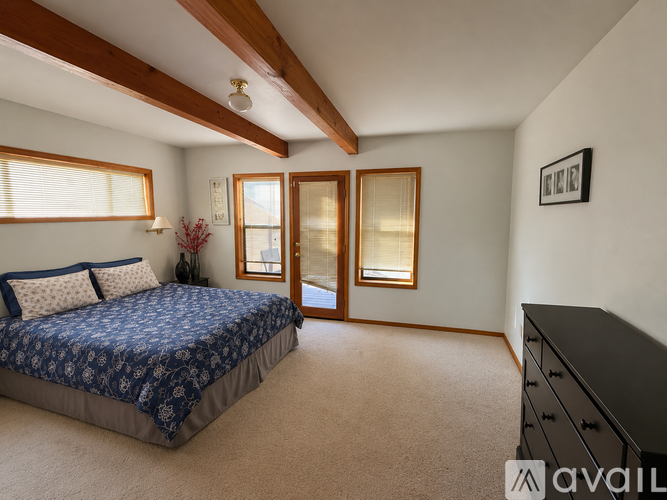 A bedroom with a large bed and a dresser.