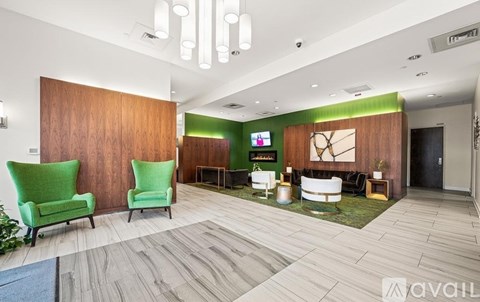 A living room with a green chair and a wooden wall.
