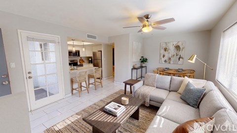A living room with a white couch and a wooden coffee table.