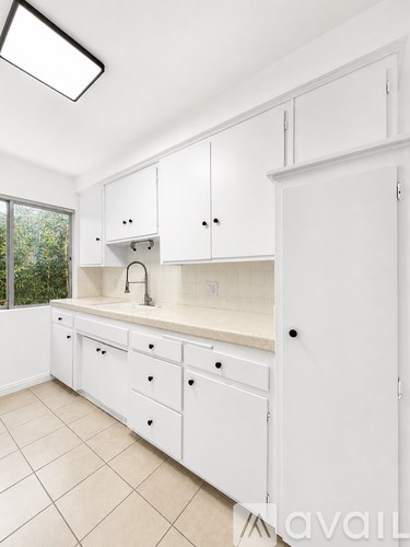 A kitchen with white cabinets and a sink.