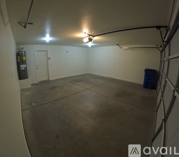 A spacious garage with a concrete floor and a ceiling fan.