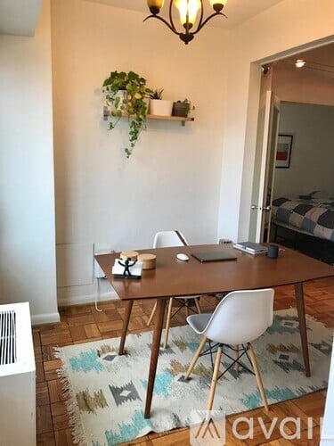 A dining room with a wooden table and white chairs.