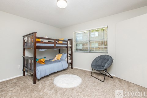 A child's bedroom with a bunk bed and a chair.