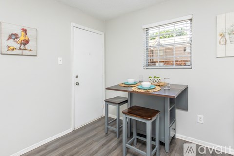 A kitchen with a table and chairs.