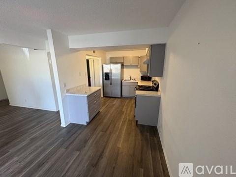 A kitchen with white cabinets and a wooden floor.