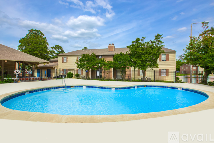 A large swimming pool in front of a building with a fence around it.