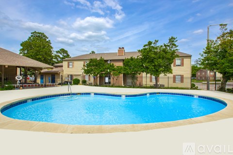 A large swimming pool in front of a building with a fence around it.