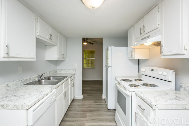 A kitchen with white cabinets and a marble countertop.