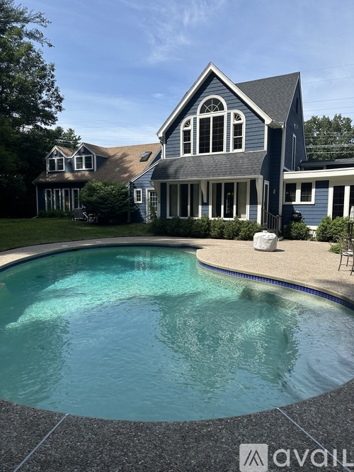 A house with a pool in front of it.