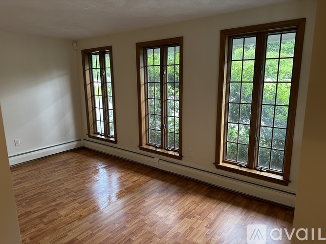 Three windows in a room with wooden floors.