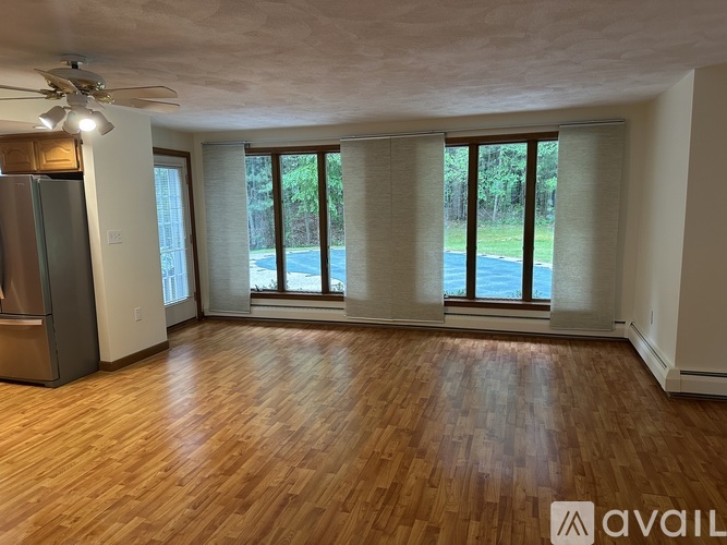 A room with wooden flooring and a ceiling fan.
