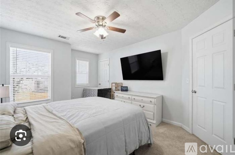 A bedroom with a bed, dresser, and television.