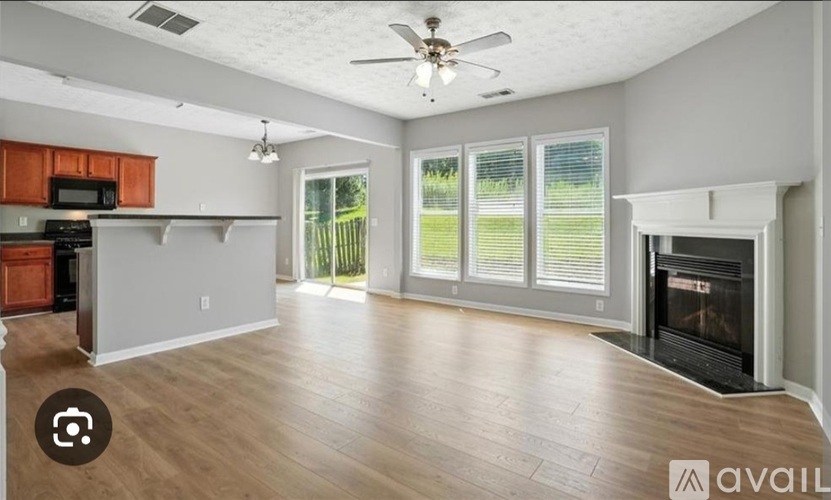 A spacious living room with a fireplace and sliding glass doors.