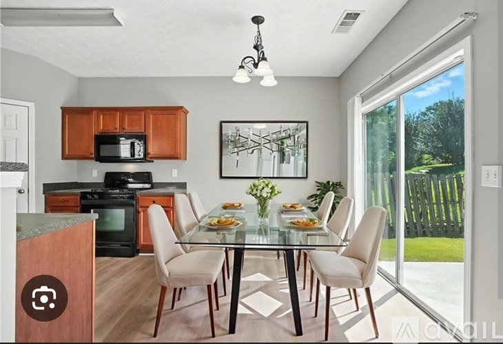 A modern kitchen with a glass dining table and chairs.