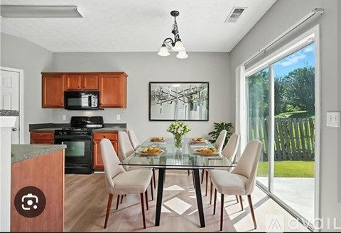A modern kitchen with a glass dining table and chairs.