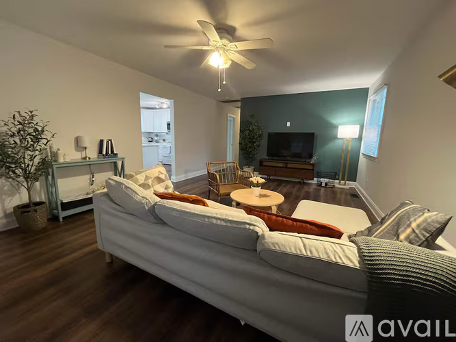 A living room with a white sofa and a ceiling fan.