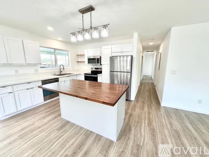 A modern kitchen with a wooden island in the middle.