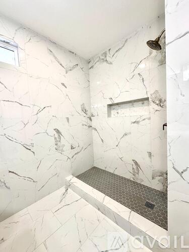 A marble bathroom with a walk in shower.