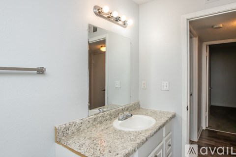 A bathroom with a granite countertop and a white sink.