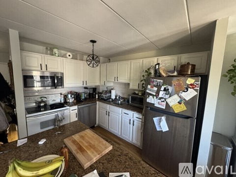 A kitchen with a refrigerator covered in notes and magnets.