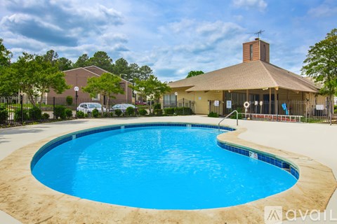 A large outdoor swimming pool with a building in the background.