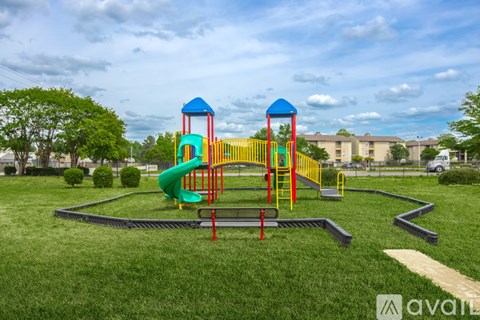 A playground with a green slide and a red and yellow structure.